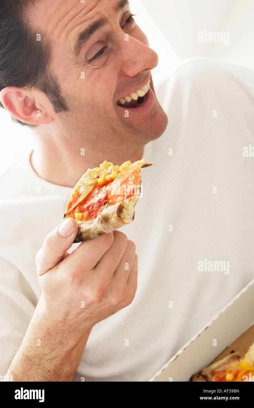 Un homme d'une quarantaine d'eating pizza Banque D'Images