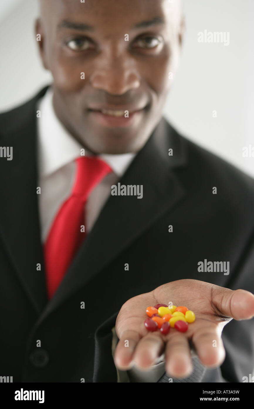 Un homme d'affaires avec une poignée de bonbons haricots Banque D'Images