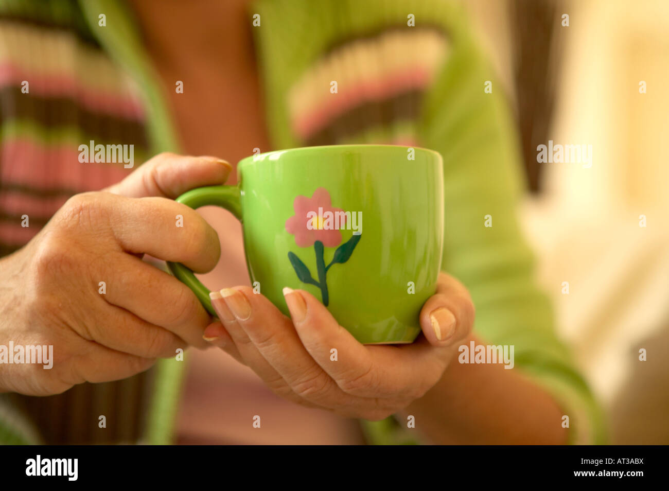 Une femme tenant une tasse de café dans ses mains Banque D'Images