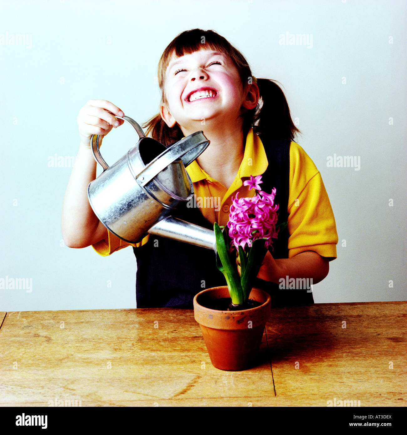 Une petite fille d'arroser une plante Banque D'Images