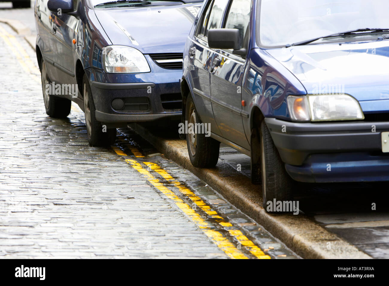 Deux voitures garées sur les lignes jaunes doubles lumineuses aucun stationnement marquage routier Banque D'Images