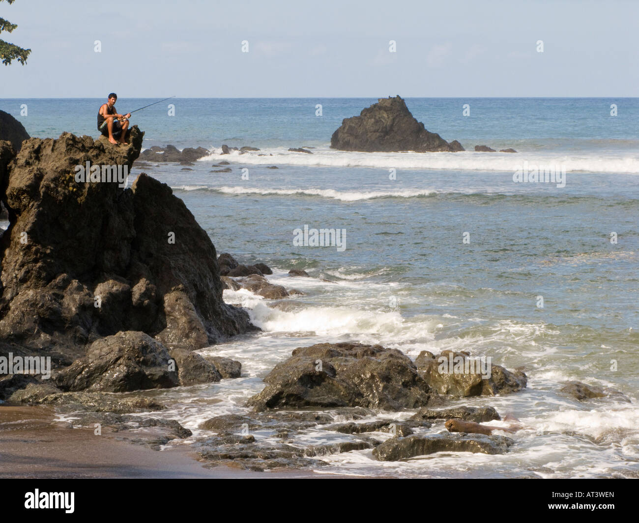 Costa Rica Péninsule d'Osa man fishing de rivage rocheux à l'embouchure de la rivière Rio Clara Banque D'Images