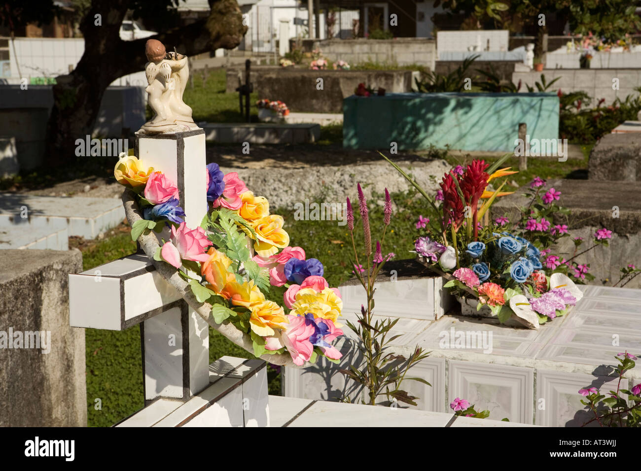 Costa Rica Péninsule d'Osa Puerto Jimenez fleurs en plastique sur le sol carrelé de graves en ville cimetière Banque D'Images