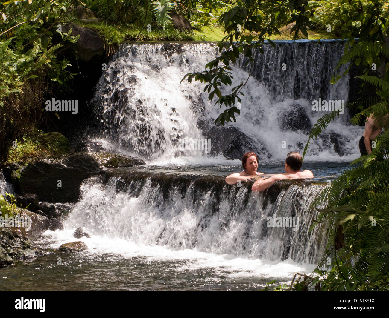 Costa Rica La Fortuna Tabacon Hot Springs Resort vous assis dans la piscine entre une chute d'eau chauffée thermiquement Banque D'Images