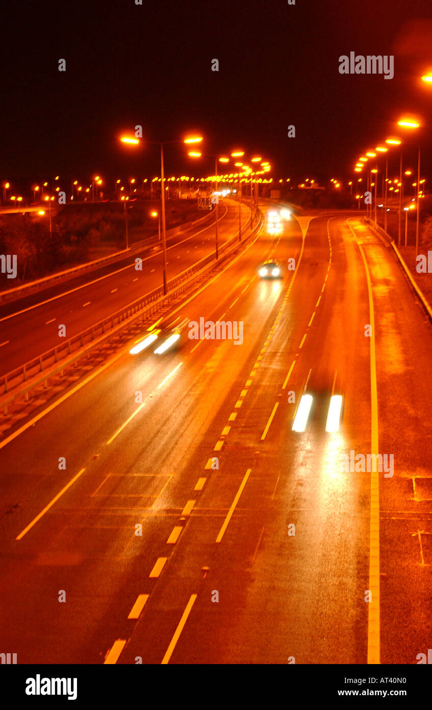 Autoroute à la nuit avec des voitures et des lumières de rue Banque D'Images