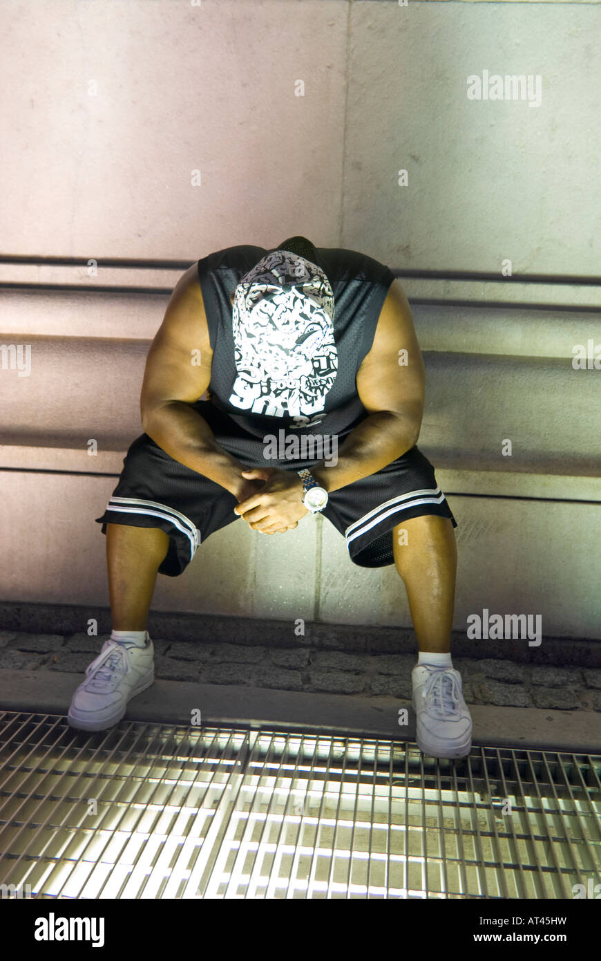 L'homme, afro-américain, assis, tête en bas, à cap Banque D'Images