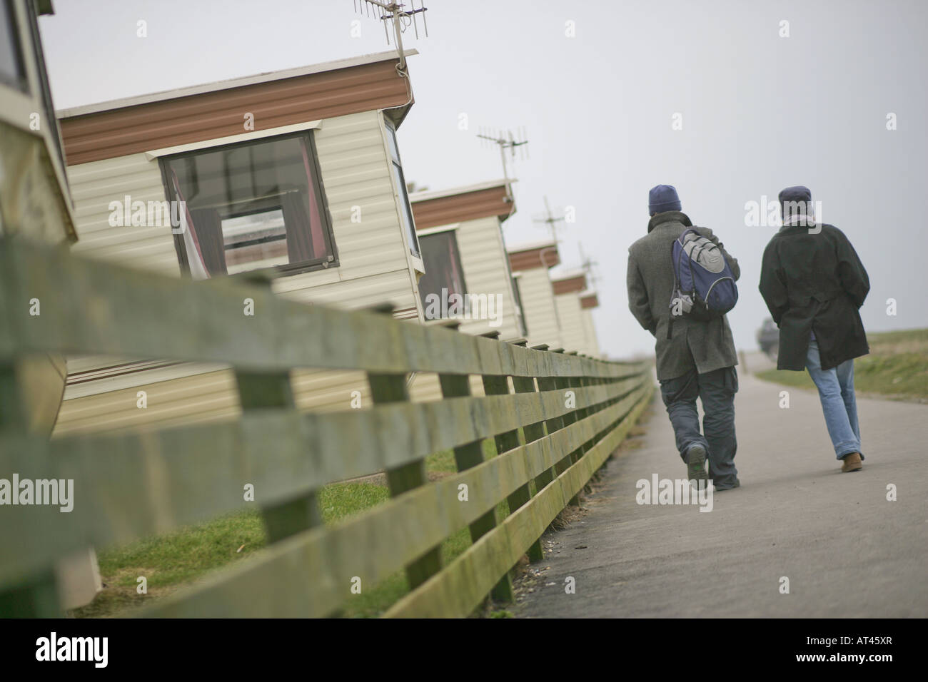 Un anonamous couple marche passé vieillissement caravan site dans un seasdie ville Banque D'Images