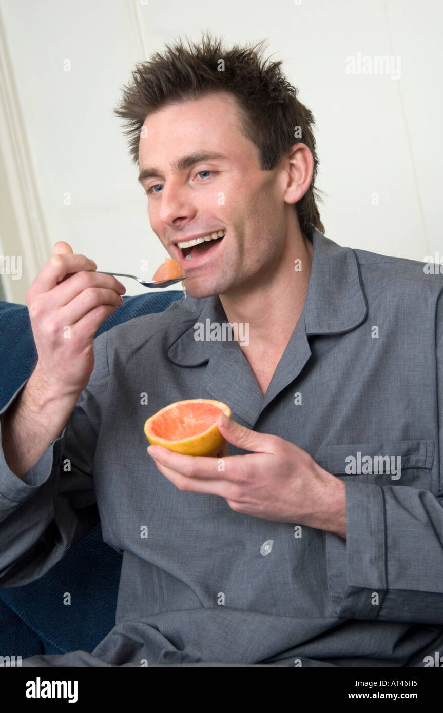 L'homme de manger un pamplemousse pour le petit déjeuner Banque D'Images