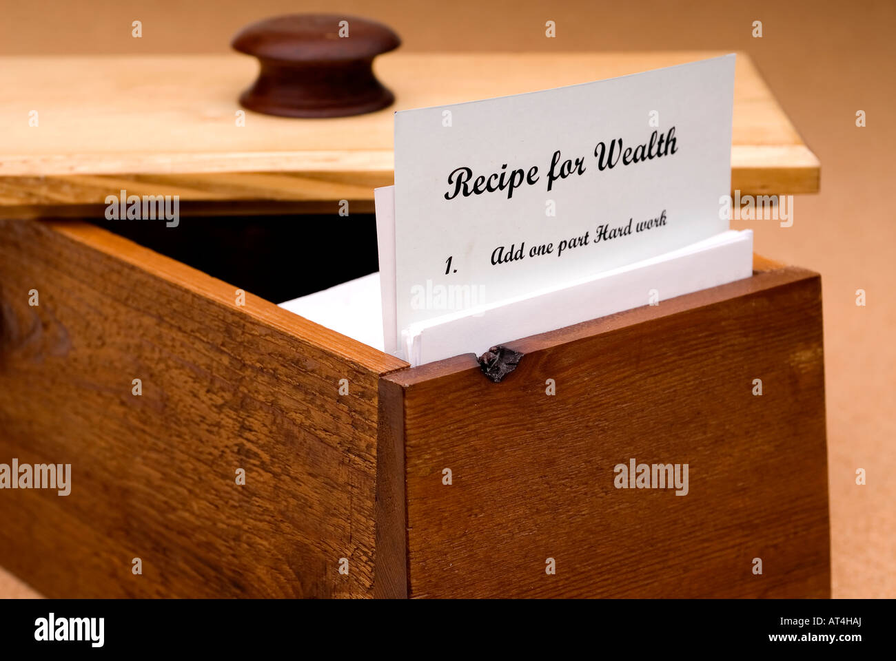 Un concept d'une recette pour la richesse contenue dans une fiche recette dans une boîte à recettes en bois Banque D'Images