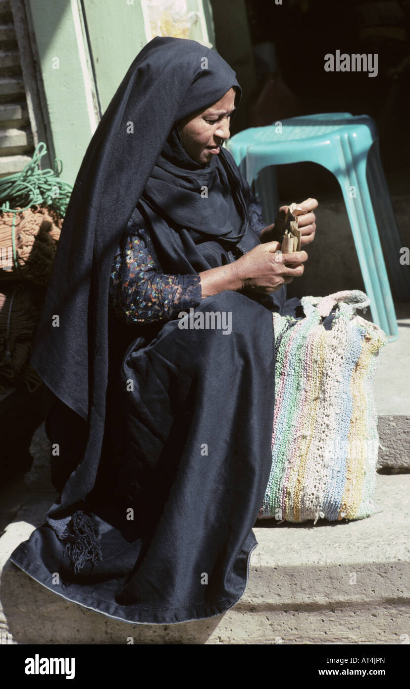 Une femmes égyptiennes dans le noir traditionnel robe arabe s'arrête dans  la rue à Louxor Egypte tout en faisant ses courses Photo Stock - Alamy