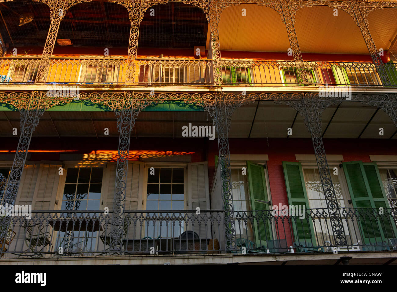 Un balcon éclairé avec coucher de soleil. Quartier français de La Nouvelle-Orléans, Louisiane, Etats-Unis. Banque D'Images