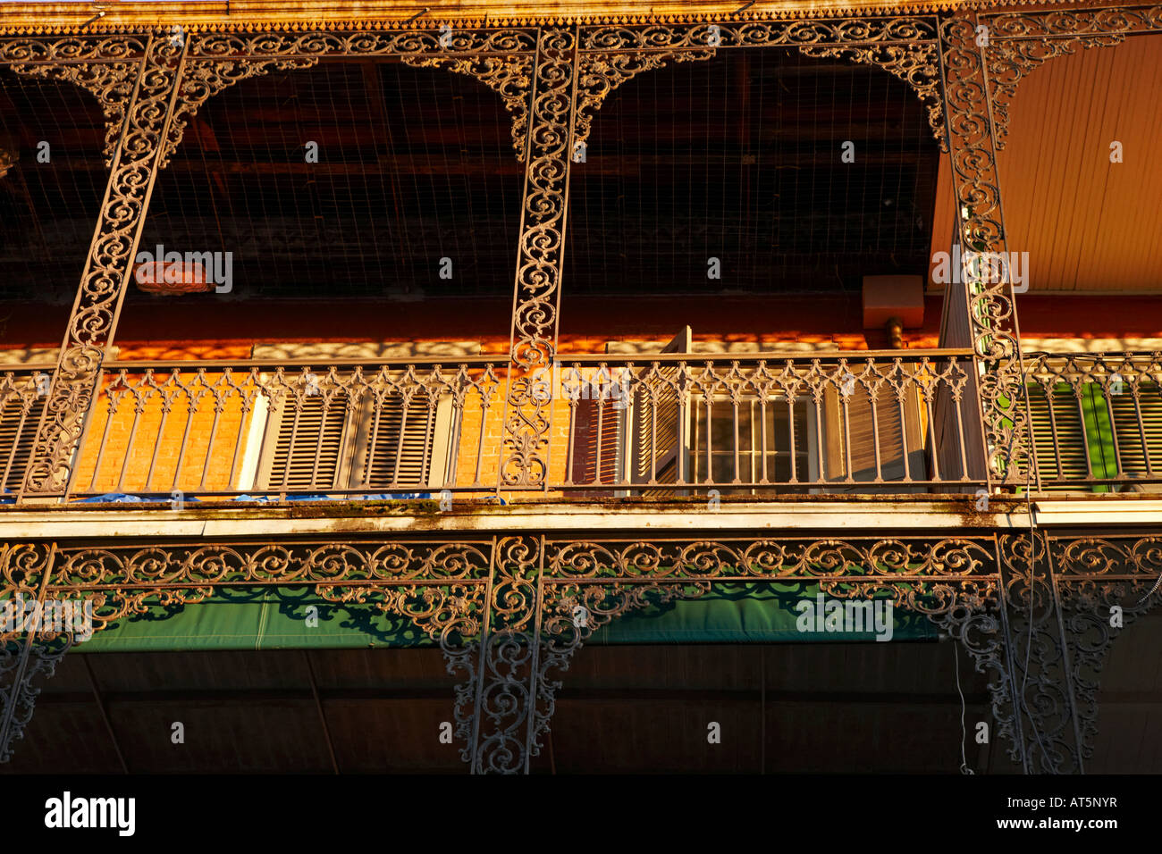 Un balcon éclairé avec coucher de soleil. Quartier français de La Nouvelle-Orléans, Louisiane, Etats-Unis. Banque D'Images