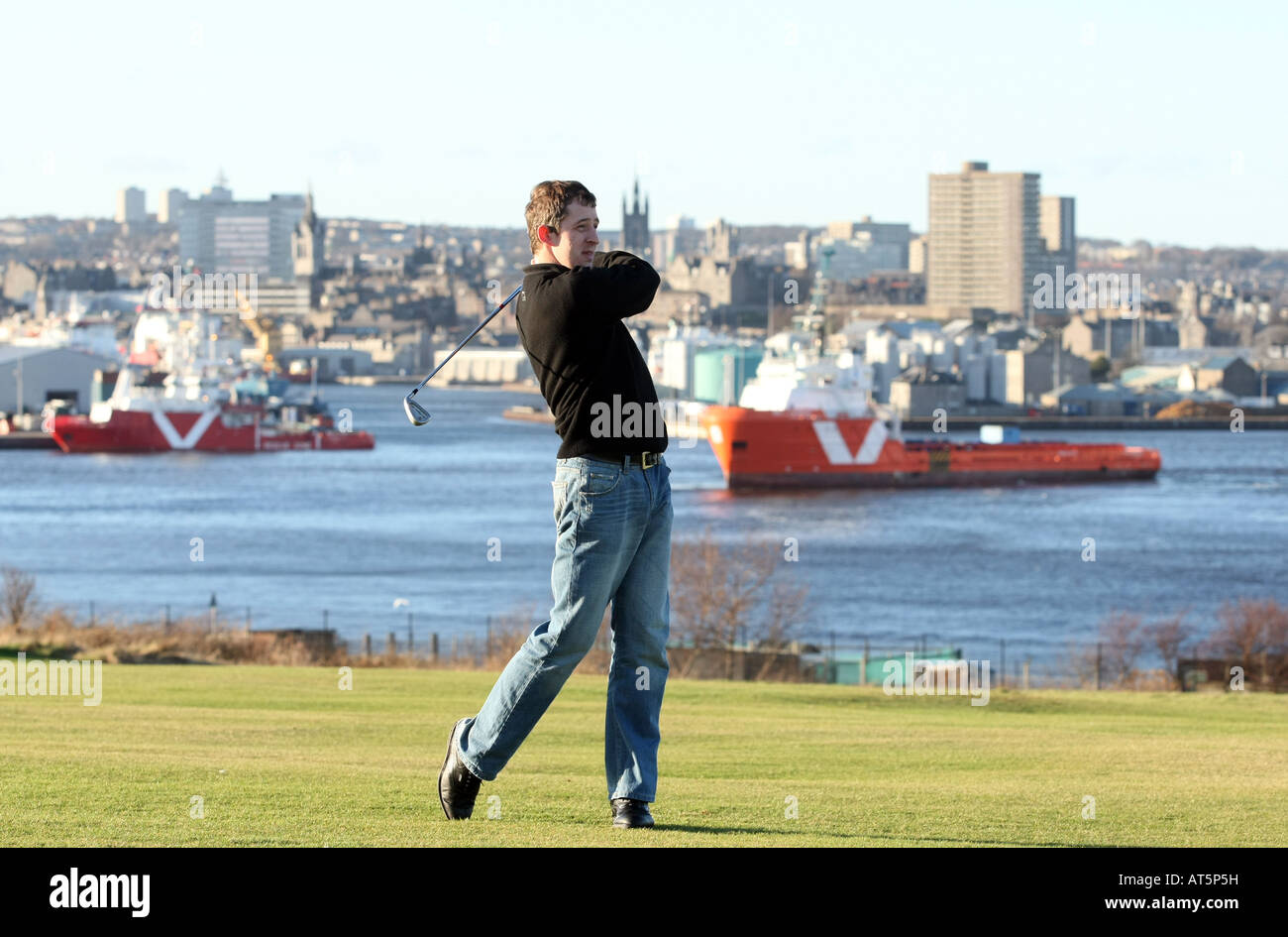 Balnagask golfeur jouant au Golf Club à Aberdeen, Écosse, Royaume-Uni, avec un panorama de la ville en arrière-plan Banque D'Images