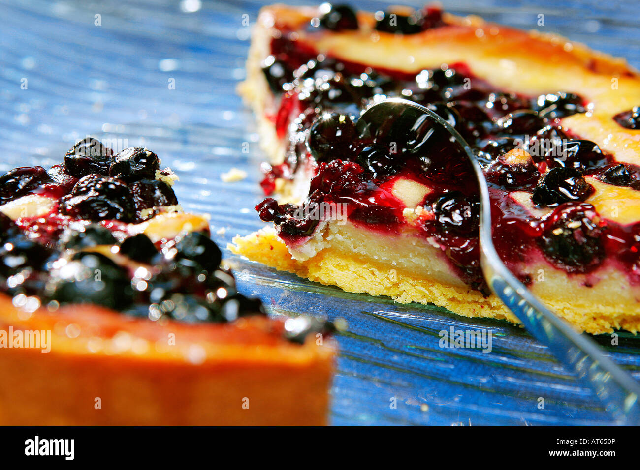 Morceaux de tarte au gâteau blackberry sur une assiette bleue avec une cuillère à café Banque D'Images