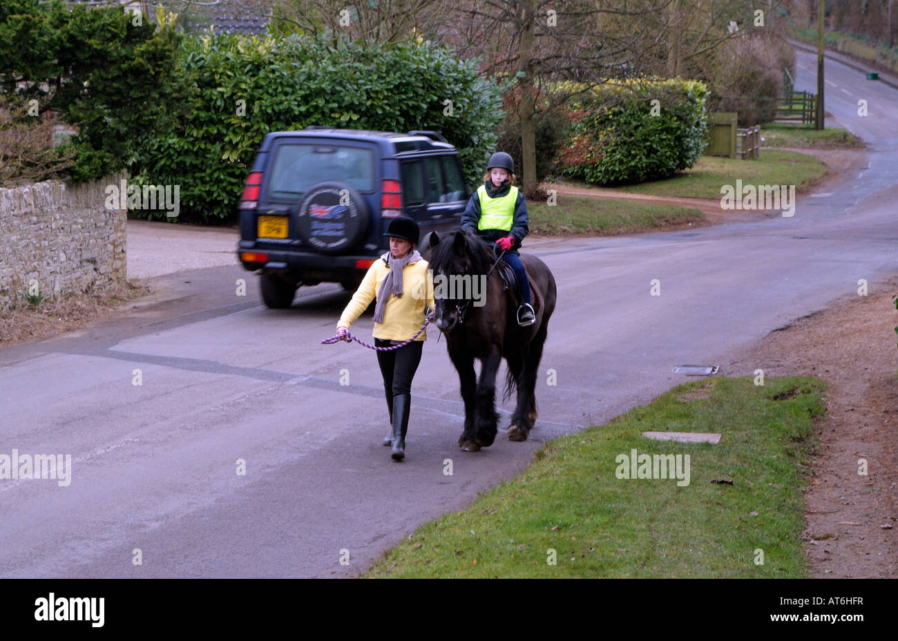 Pony et le cavalier portant un grand merci de passer et lent sur Veste country Lane avec voiture passant England UK Banque D'Images