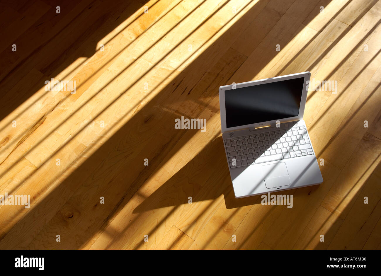 Apple ibook G4 ordinateur portable assis sur un vrai parquet dans l'après-midi soleil Banque D'Images