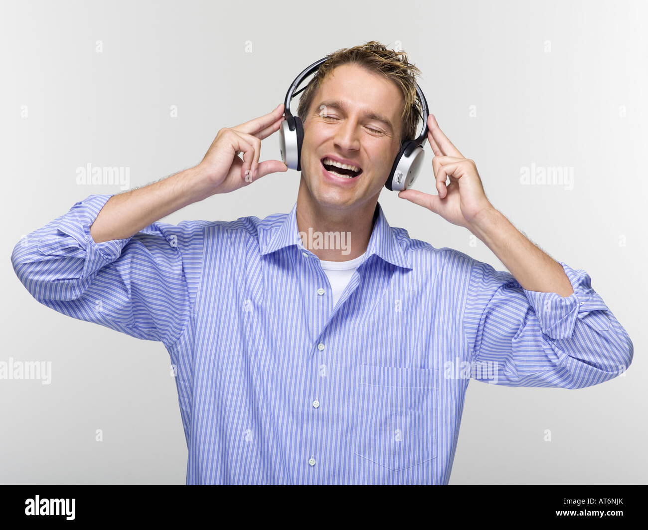 Jeune homme avec les yeux fermés à écouter de la musique Banque D'Images