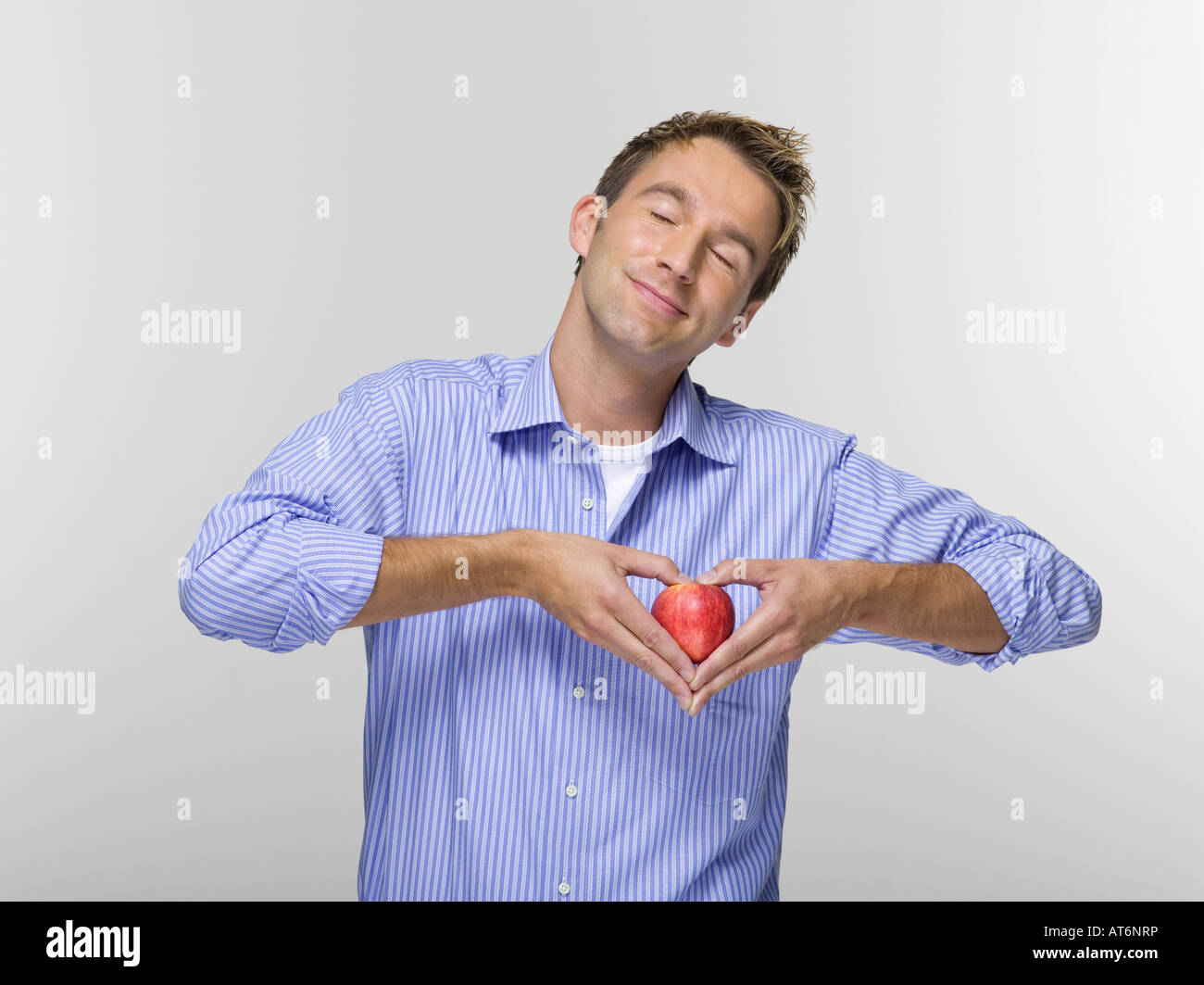 Young man holding apple, portrait Banque D'Images