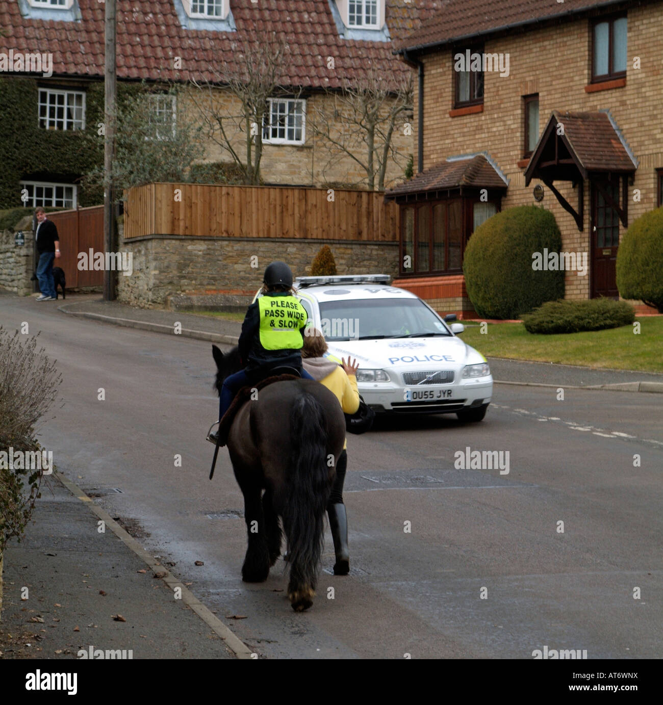 Pony et le cavalier portant un grand merci de passer et lent sur Veste country Lane avec voiture passant England UK Banque D'Images