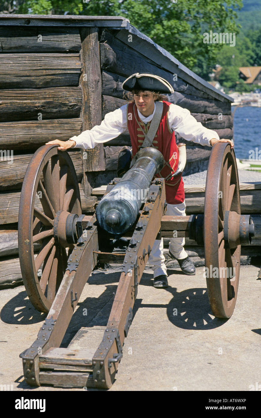 Un reenactors vêtu comme un soldat britannique se place en avant d'un canon à Fort Ticonderoga Monument Historique Banque D'Images