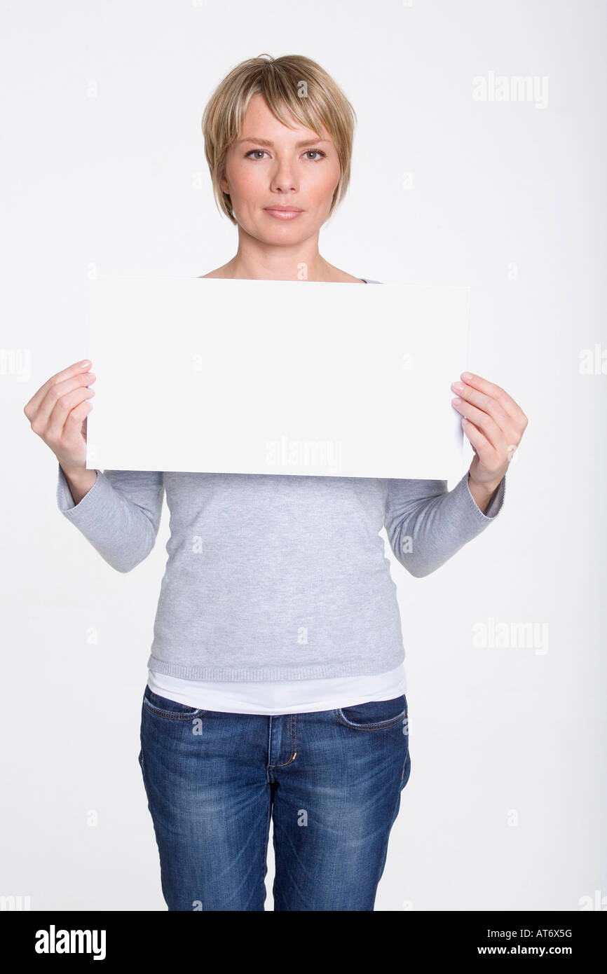 Young woman holding blank placard, portrait Banque D'Images
