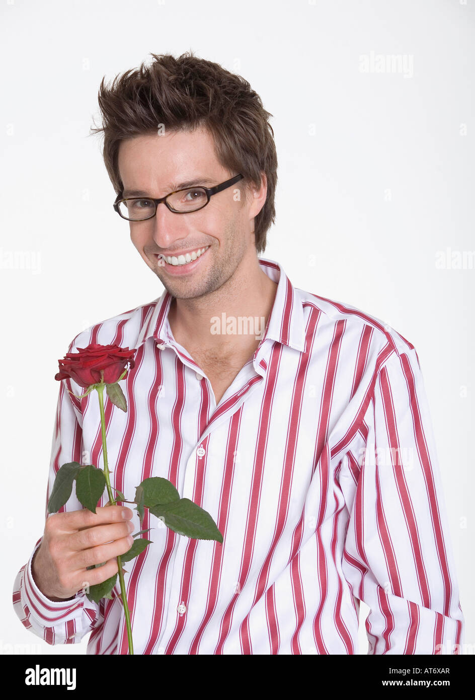 Jeune homme tenant une rose, portrait Banque D'Images