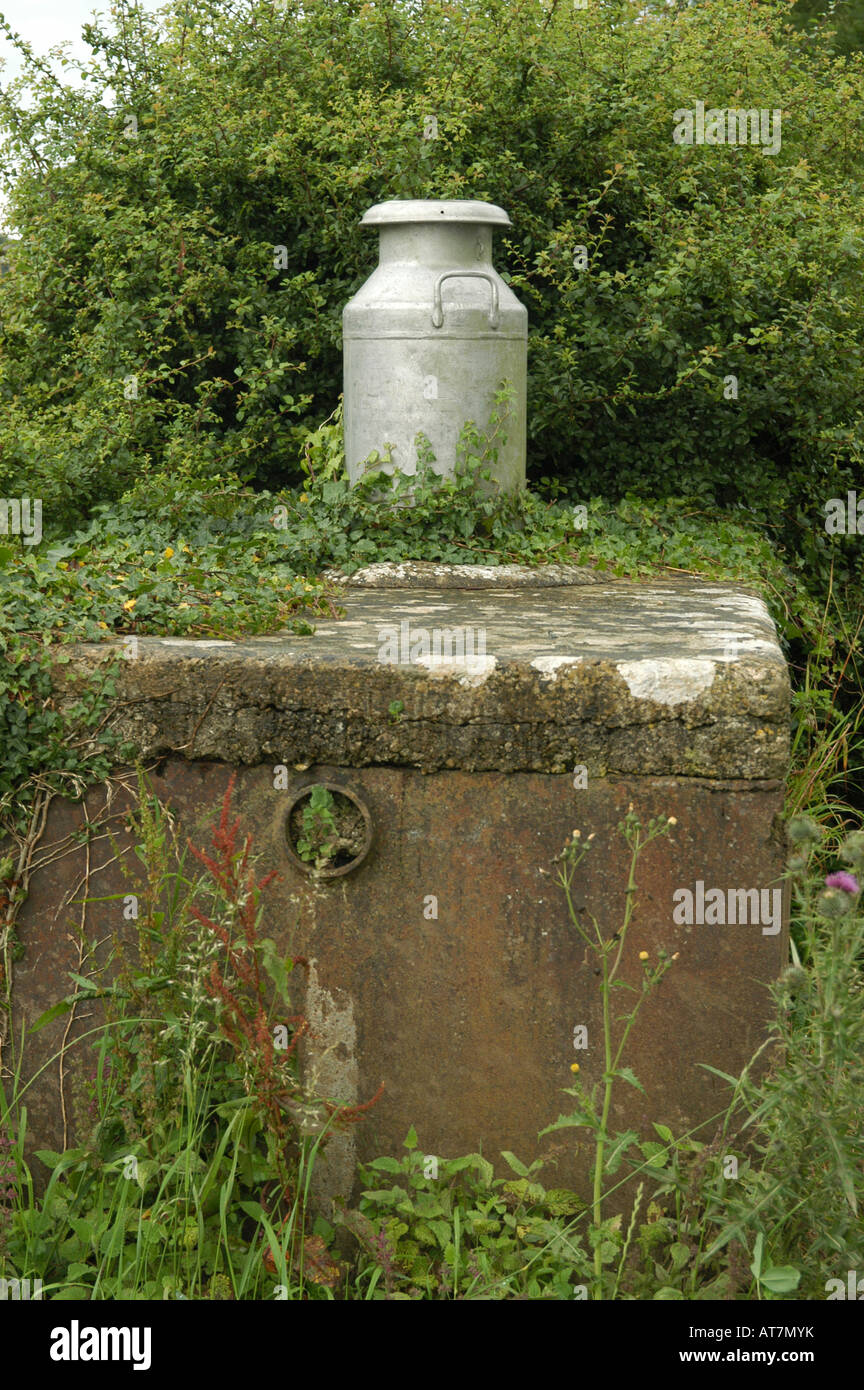 Ancien bidon de lait à un point de collecte porte ferme cotswold Banque D'Images