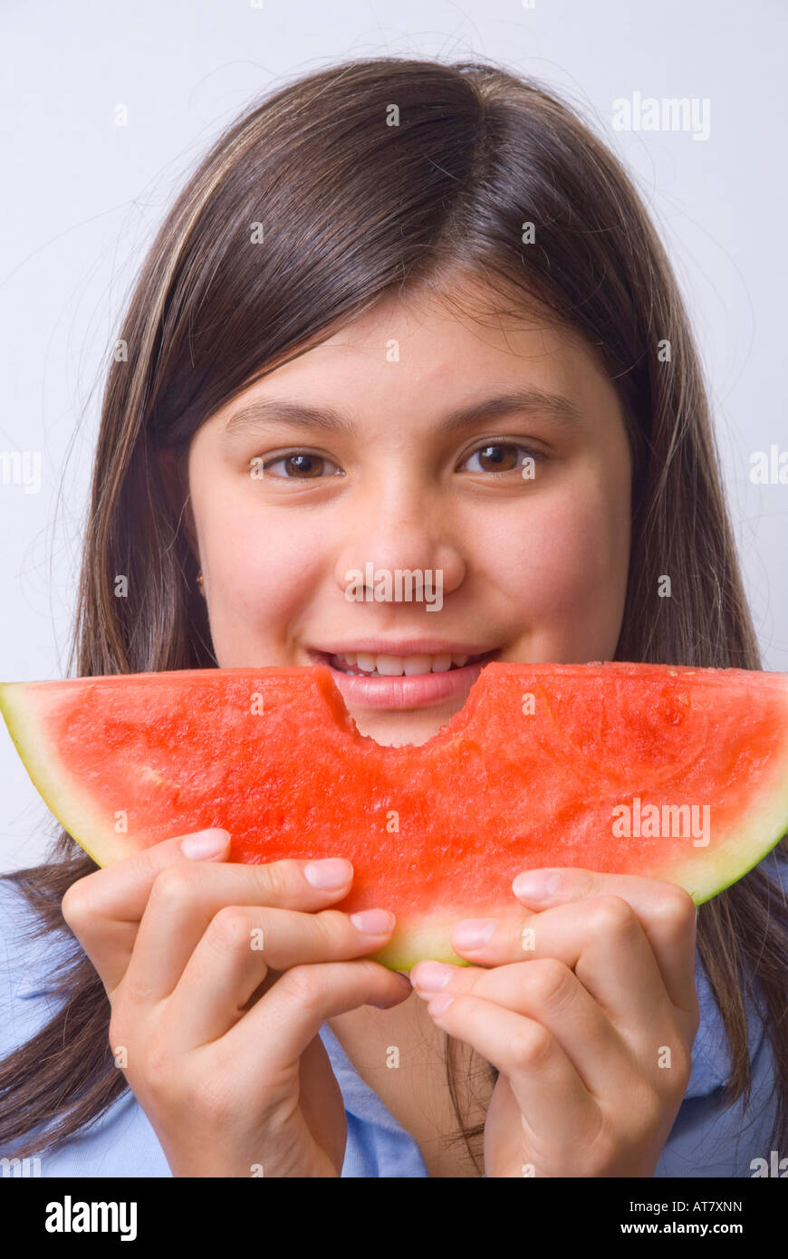 Jeune fille souriante mangeant une tranche de pastèque mûre sans pépins Banque D'Images