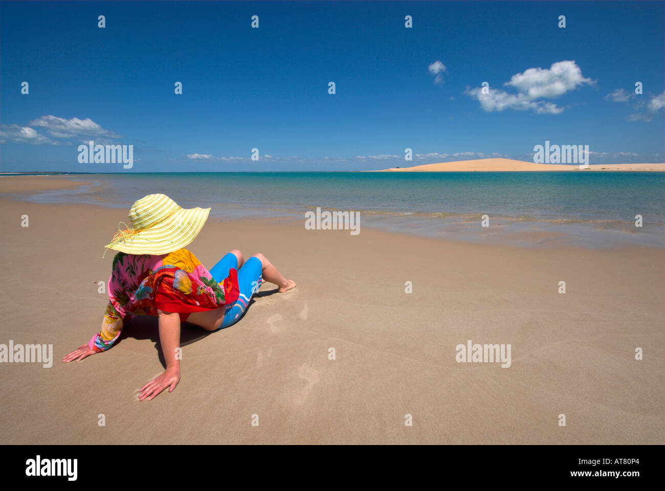 Attractive Woman sitting on beach wrap rouge Banque D'Images