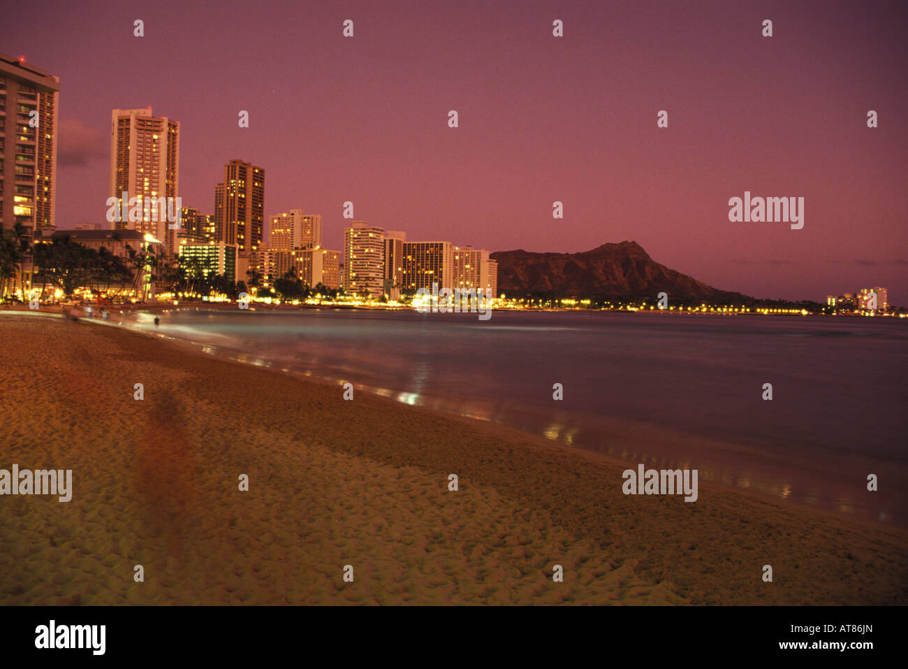 Les lumières de Waikiki et la silhouette de la Tête du Diamant comme vu de la plage de Waikiki peu après le coucher du soleil. Banque D'Images