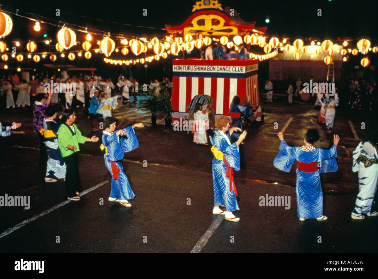 Bon danseurs dans diverses poses cercle autour d'un culte tendu avec des centaines de lanternes à Nuuanu, sur l'île d'Oahu. Banque D'Images