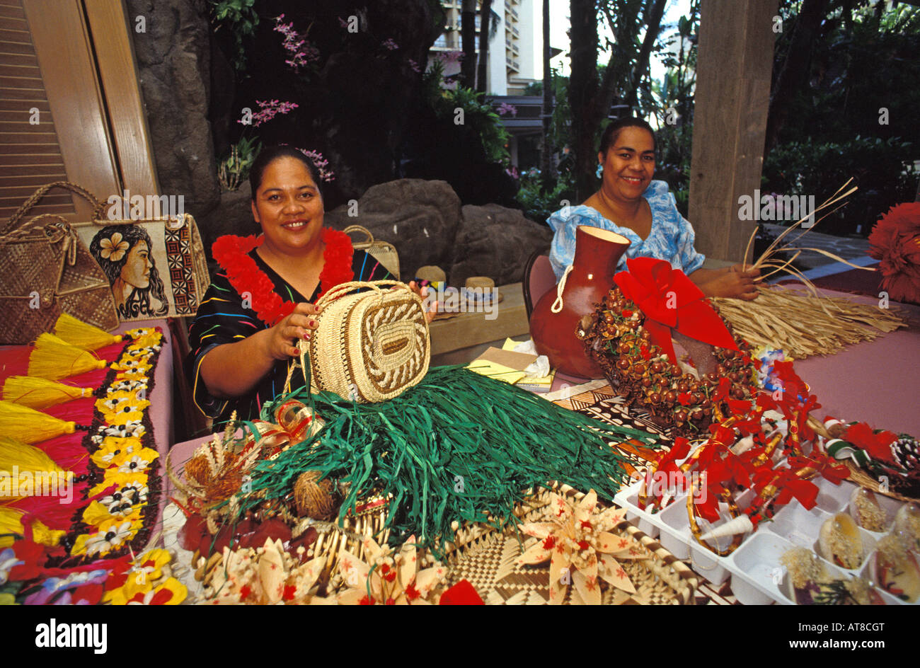 Deux femmes hawaïennes tout en faisant sourire tissé coloré d'objets d'artisanat. Banque D'Images