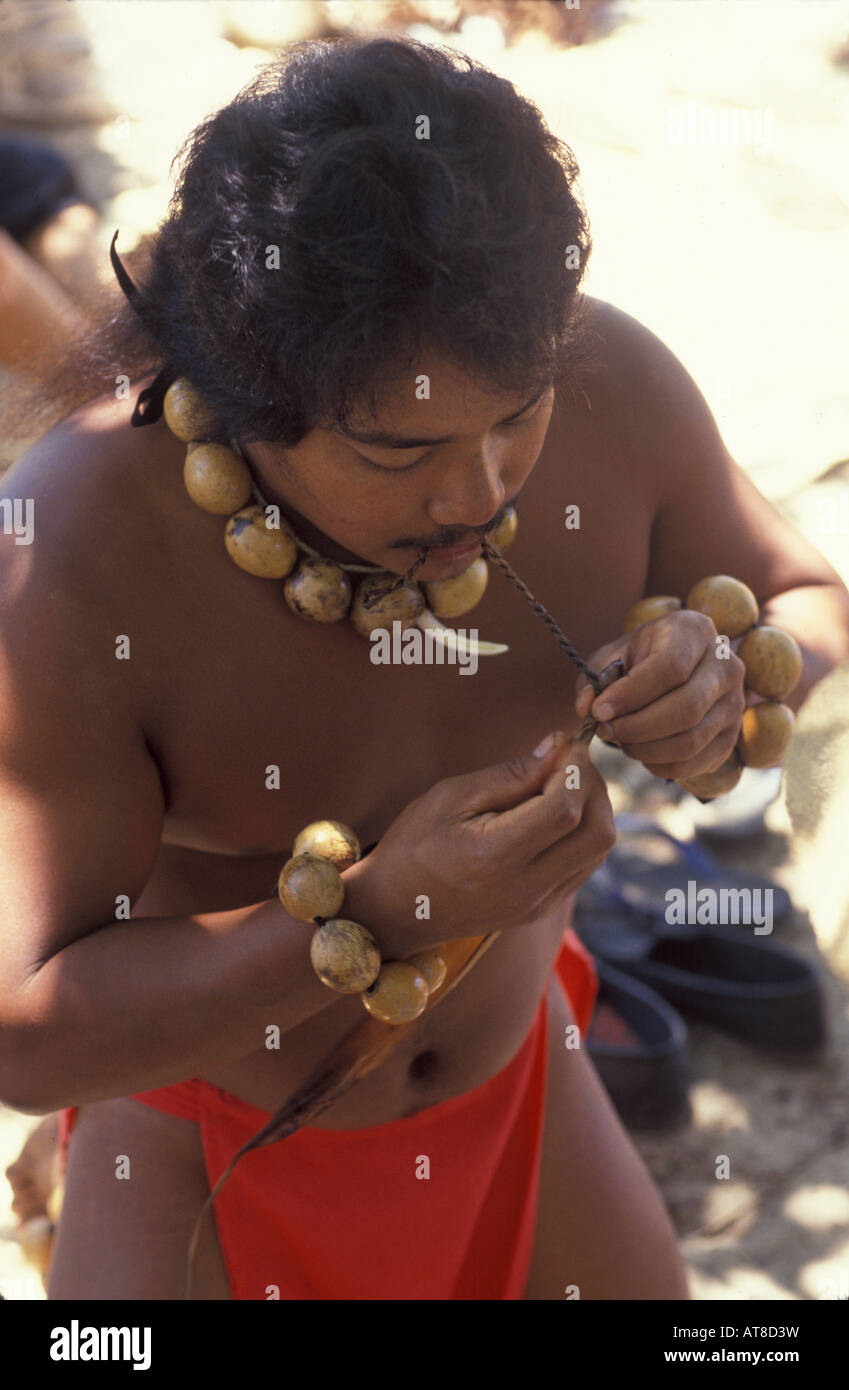 Jeune homme hawaïenne démontrant comment les anciens hawaiiens fait ficelle. Banque D'Images