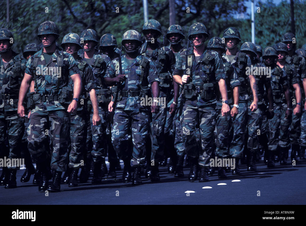 Close-up d'une unité militaire de jeunes soldats, des robes en combat treillis, casques et bottes, marchant vers le bas de l'Avenue Kalakaua Banque D'Images