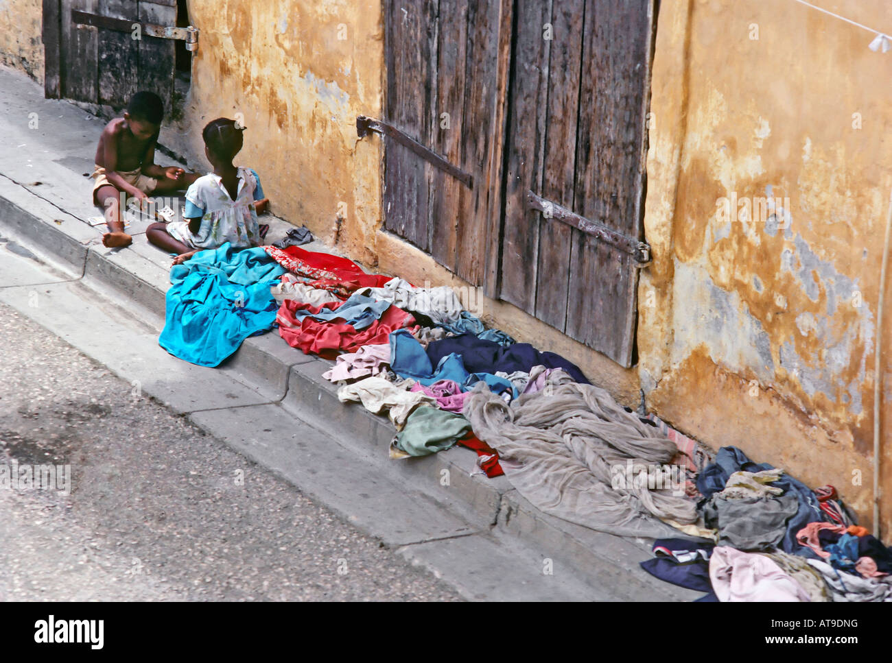 Enfants jouant dans une rue avec blanchisserie séchage au Cap Haïtien haïtien Banque D'Images