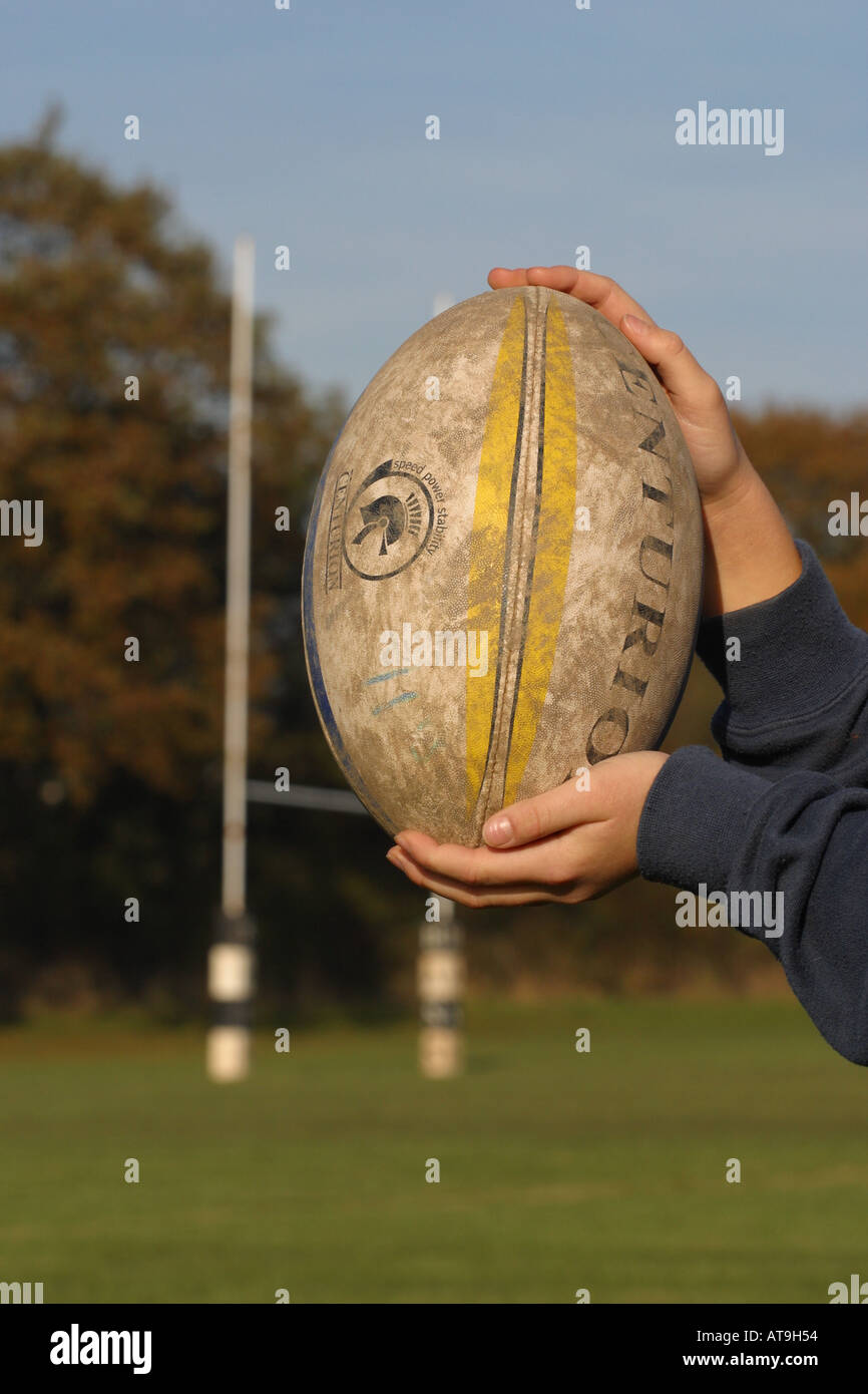 Tenant un ballon de rugby en face de rugby poteau de but Banque D'Images