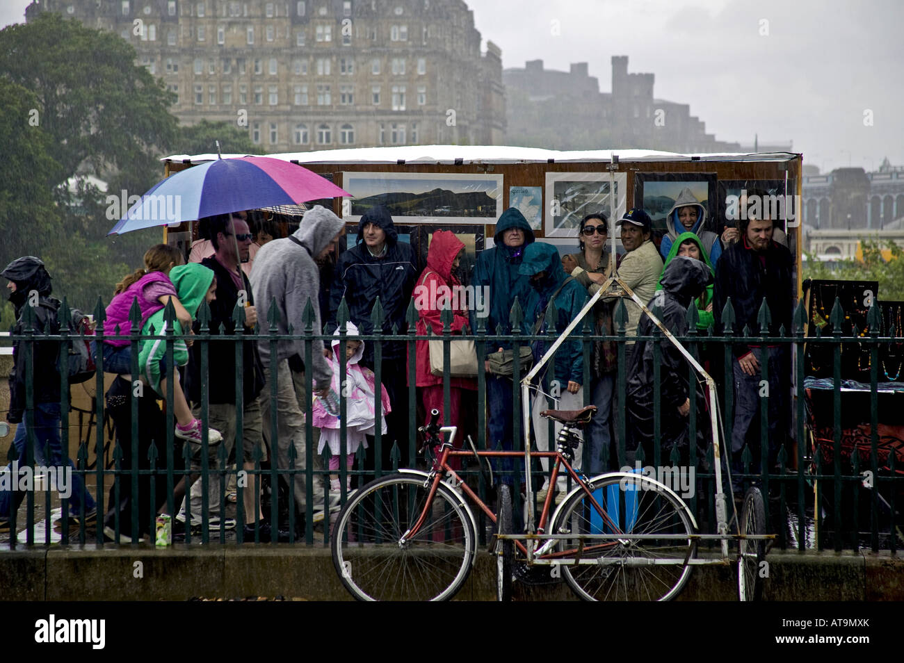 Les touristes à l'abri de l'art photographique à partir de la cabine de douche de pluie lourde, Edinburgh Fringe Festival, Écosse, Royaume-Uni, Europe Banque D'Images