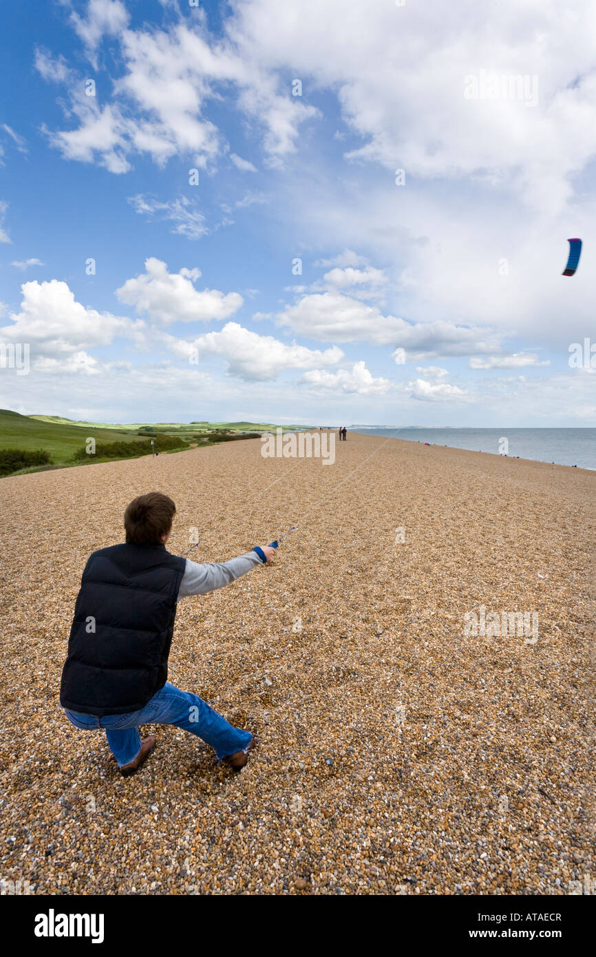 Un jeune battant une aile de traction sur la plage de Chesil, Dorset Banque D'Images