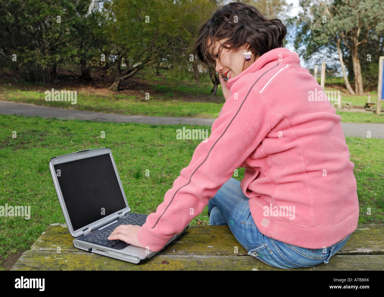 Une jeune fille asiatique en utilisant un ordinateur portable en plein air Banque D'Images