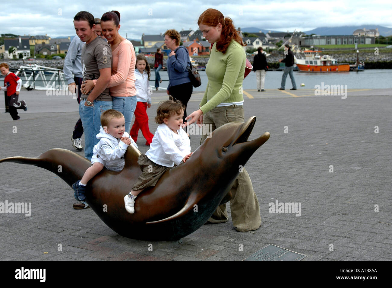 Les enfants voyagent la figure de bronze du dauphin champignons qui a contribué à faire une destination doit voir Dingle Banque D'Images