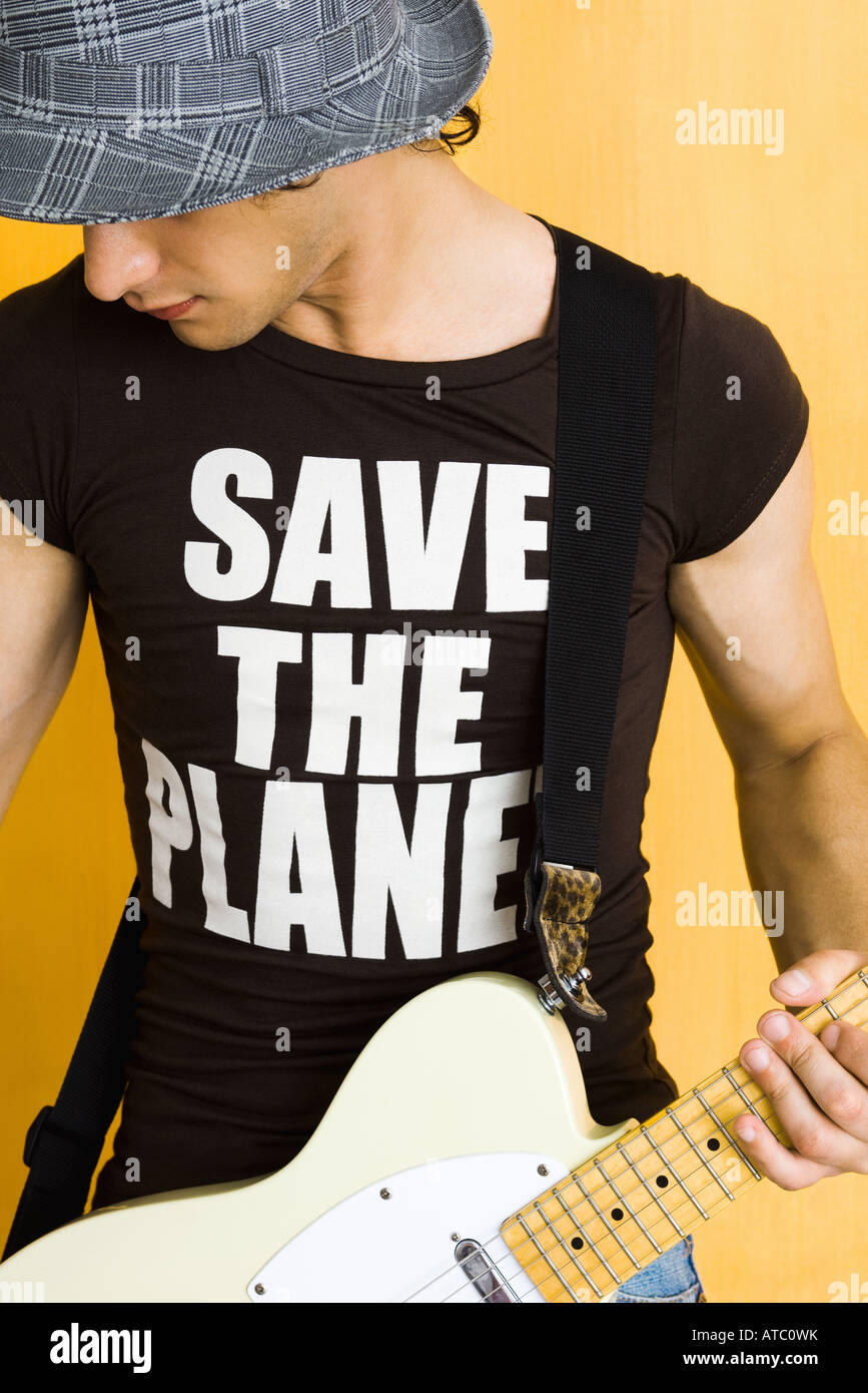 Jeune homme jouant de la guitare électrique, le port de tee-shirt  'enregistrer la lecture la planète' Photo Stock - Alamy
