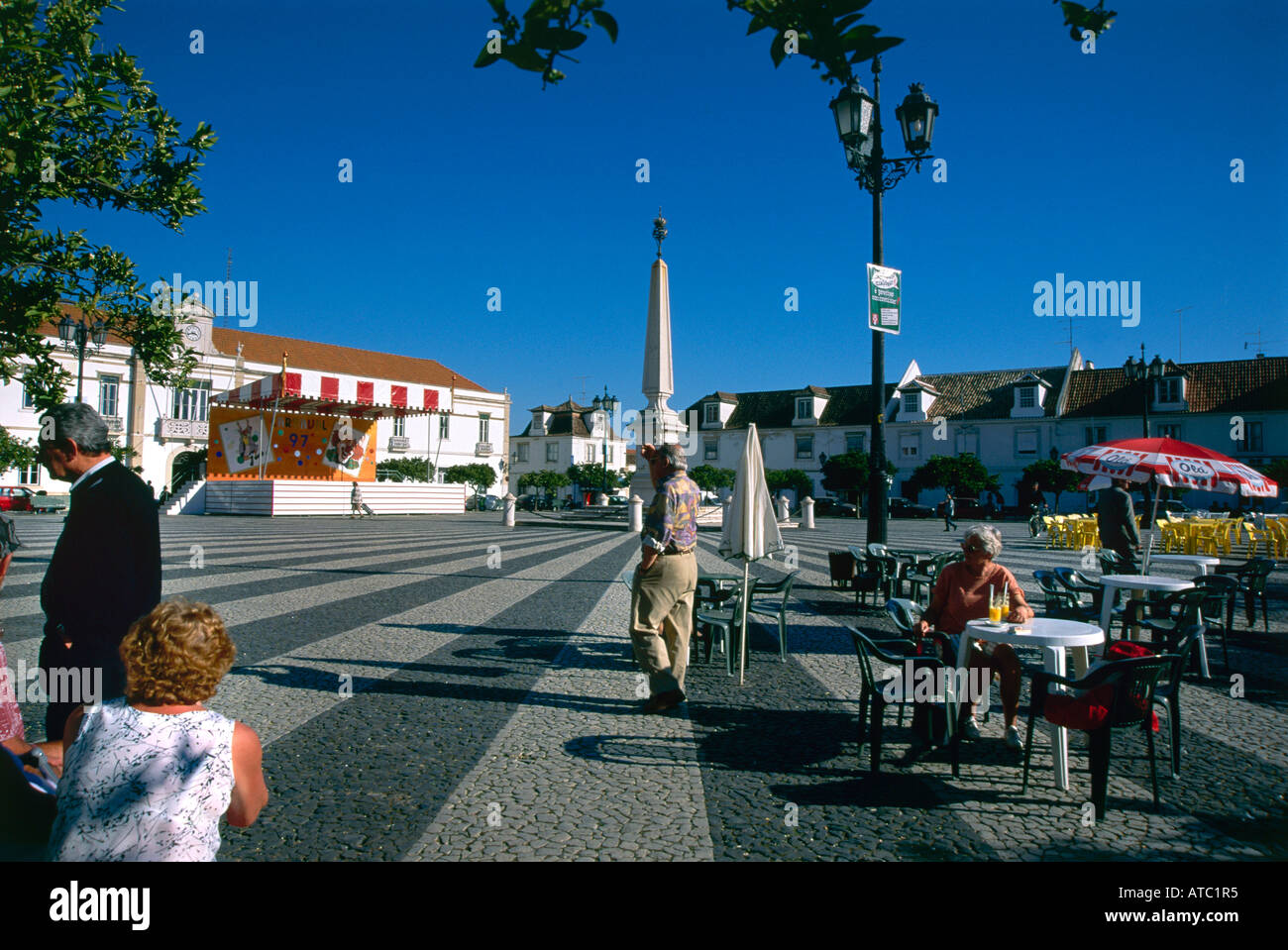 Les vacanciers se détendre autour des tables de café qui débordent sur la place principale de Vila Real de Santo Antonio Banque D'Images