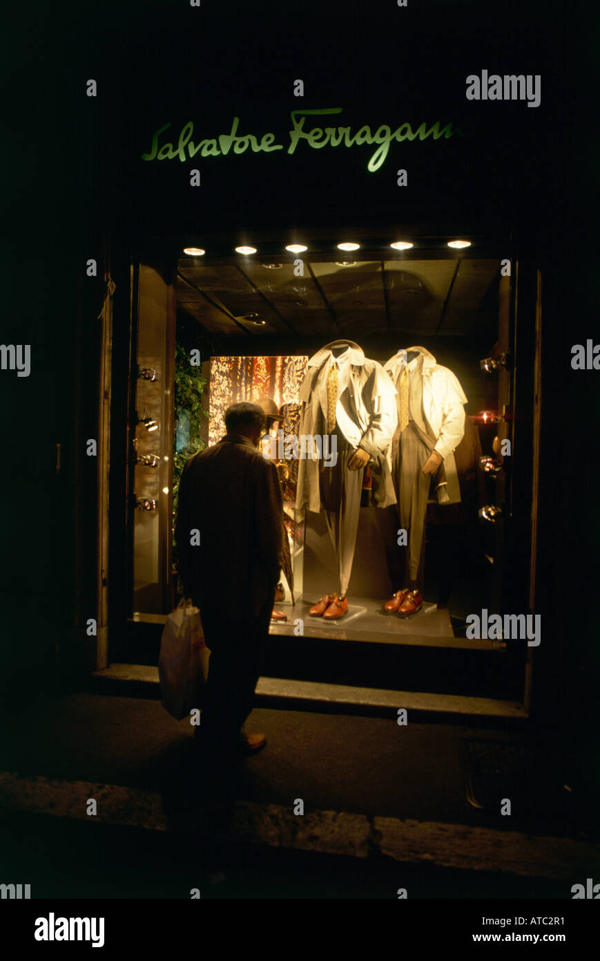 Un homme en regardant une vitrine éclairée pour la nuit shopping dans un établissement de haute couture dans la Via Condotti, l'une des rues commerçantes de Rome, où tous les grands noms de la mode pour hommes et femmes peuvent être trouvés Banque D'Images