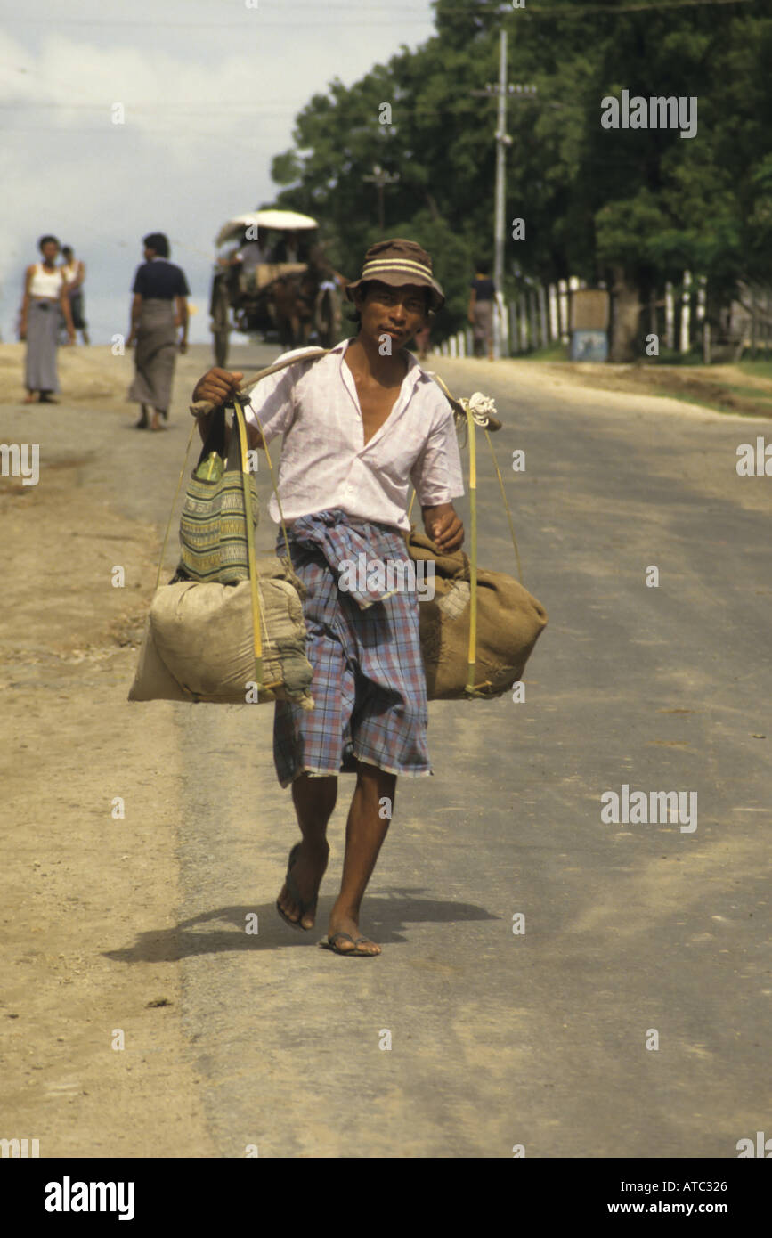 Birmanie Myanmar Village Thazi homme portant sur ses épaules les poids lourds Banque D'Images