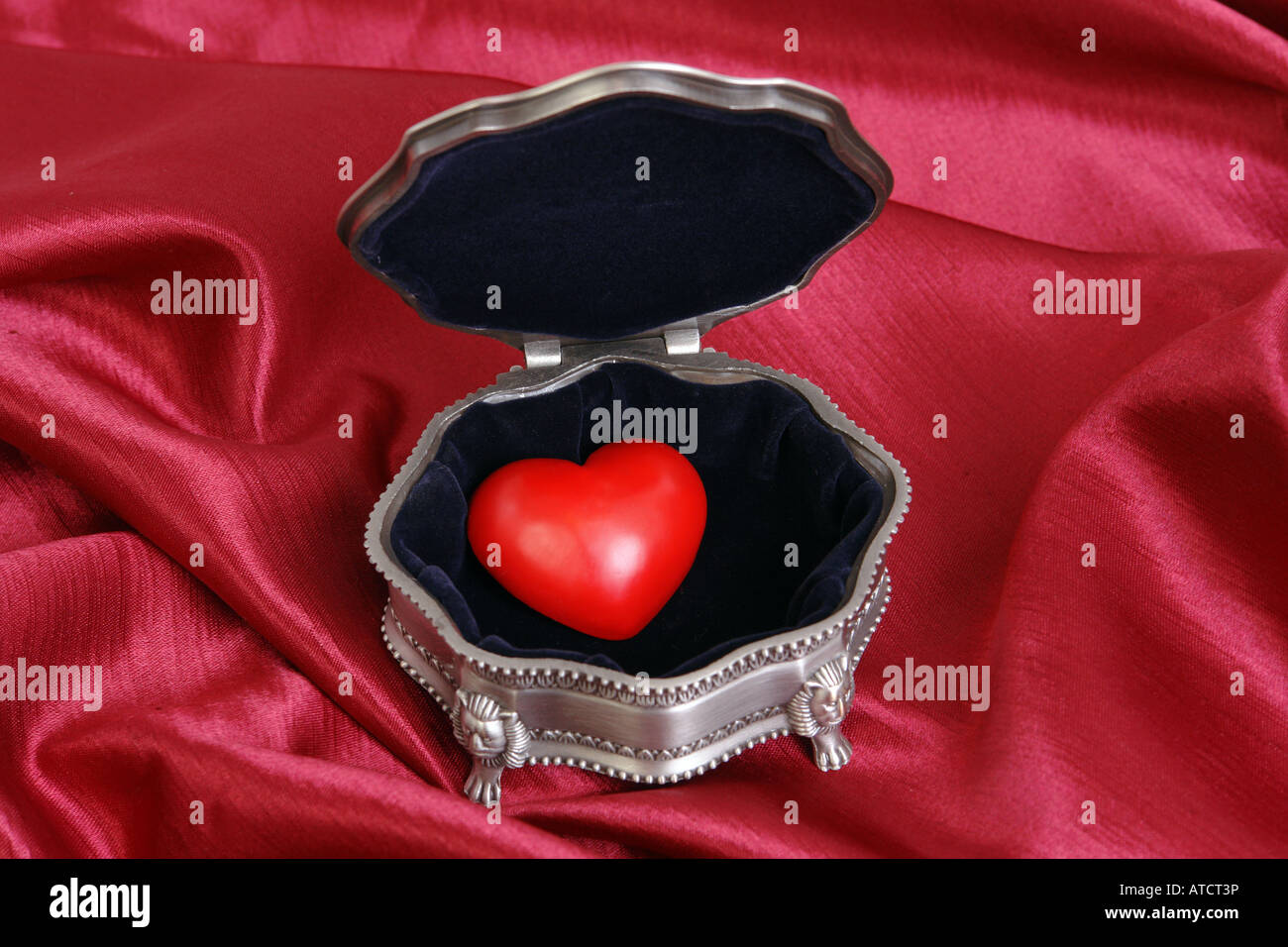 Boîte en argent avec coeur rouge tissu pourpre plus Banque D'Images
