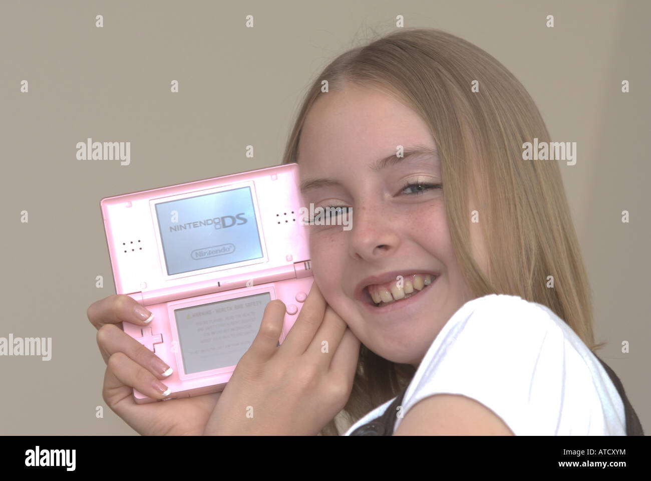 Jeune fille tenant une console de jeux Nintendo DS lite UK Banque D'Images