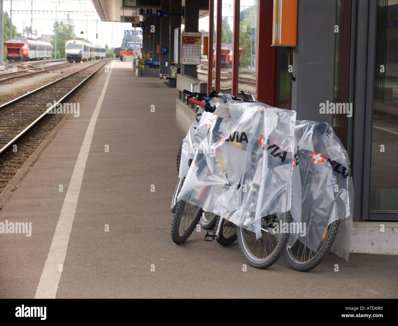 Vélos de montagne couverte de plastique de protection d'attente à la gare pour le transport sur prochain train Sarnen Suisse Banque D'Images