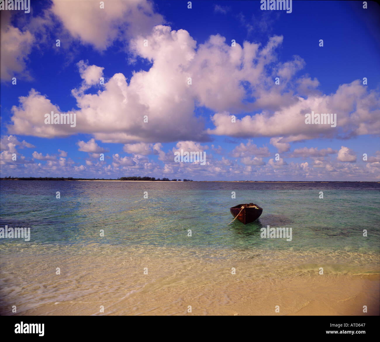 Un petit bateau en bois est mouillée au large de la côte d'une plage tranquille aux Bahamas Banque D'Images