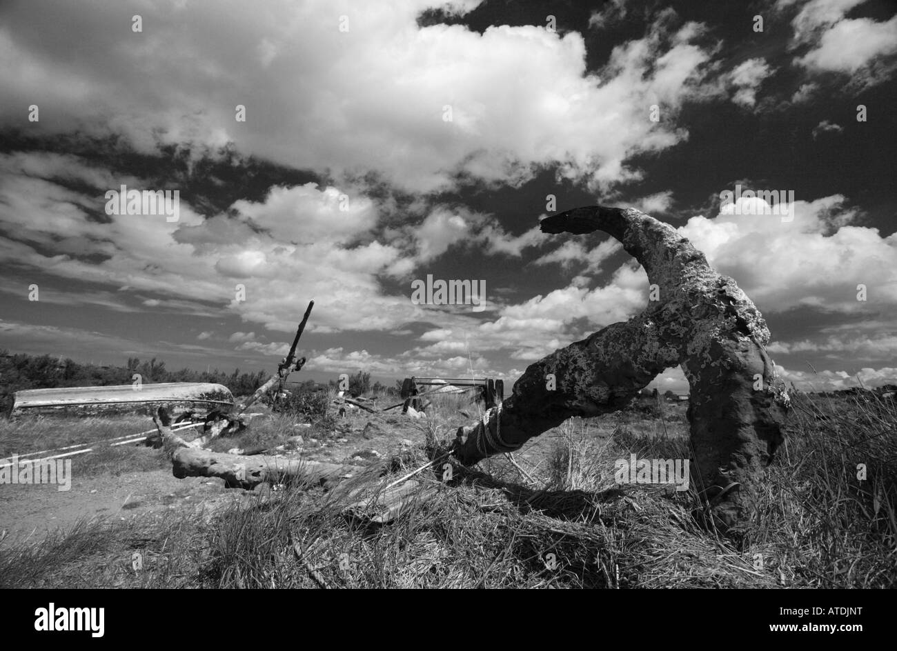 Tourné en noir et blanc d'une vieille ancre sous un ciel dramatique à Brancaster Staithe sur la côte nord du comté de Norfolk. Banque D'Images