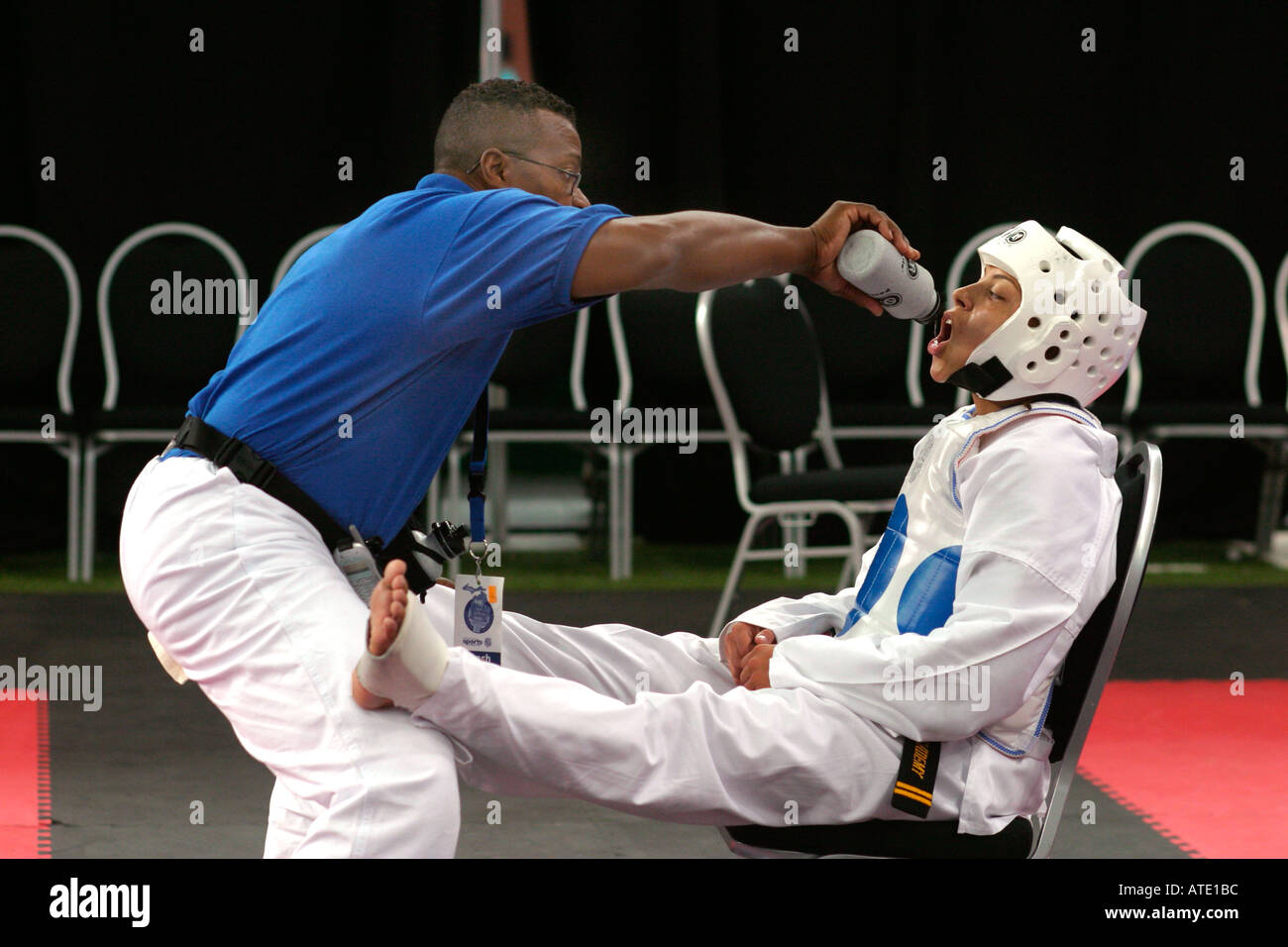 Un coach donne l'eau à un concurrent pendant l'AUA taekwondo aux Jeux Olympiques Junior à Detroit Banque D'Images